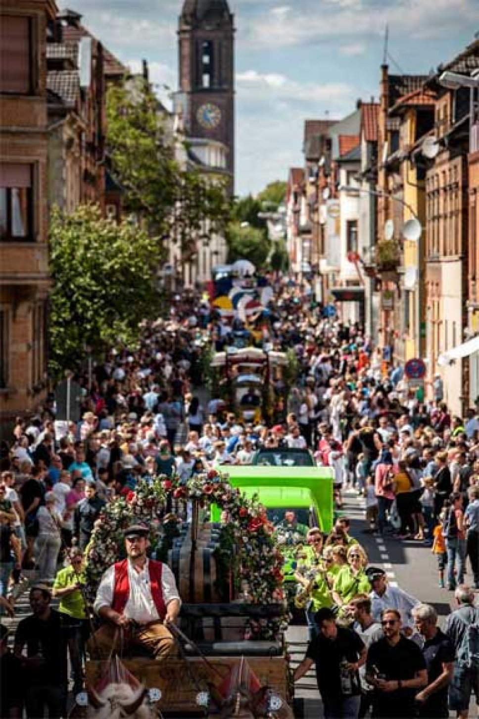 viele Menschen schauen am Straßenrand dem Backfischfest-Umzug zu