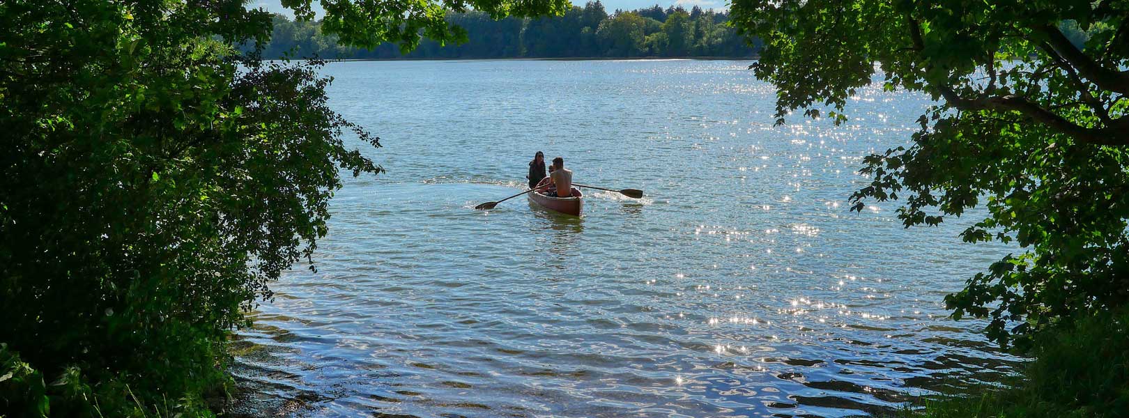 2 Personen rudern in einem Boot auf einem See 